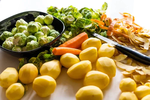 厨房桌子上的土豆皮 芽菜和胡萝卜 — 图库照片