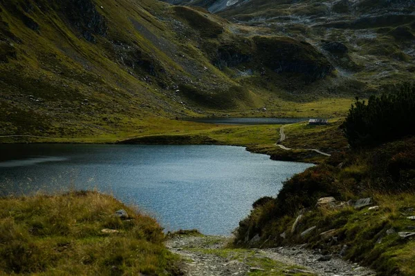 オーストリアの田舎の岩だらけの山に囲まれた青い湖の景色 — ストック写真