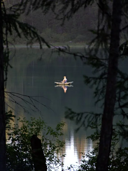 Вертикальный Снимок Человека Плывущего Каноэ Спокойному Озеру Окружении Зеленых Деревьев — стоковое фото