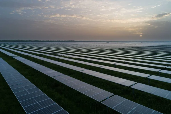 Duże Nowoczesne Panele Słoneczne Produkujące Energię Odnawialną Polach Trawiastych Zachodem — Zdjęcie stockowe