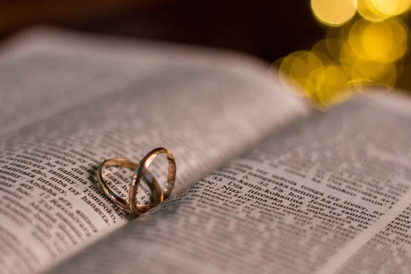 Closeup Two Wedding Rings Bible Bokeh Background — Stock Photo, Image