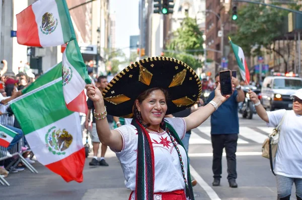 stock image A closeup shot of a happy female wearing a traditional Mexican hat and holding the flag of Mexico