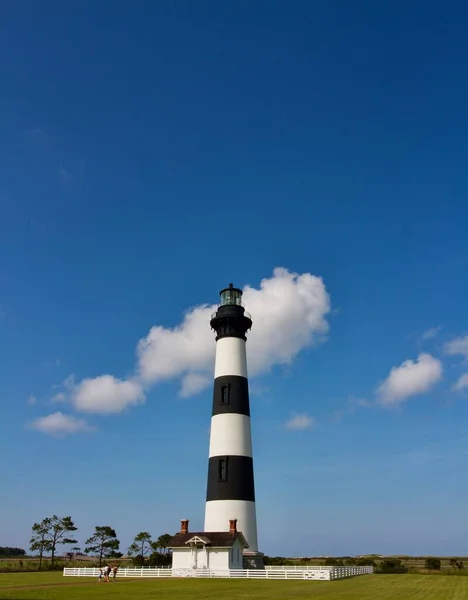 stock image A vertical shot of a black and white lighthouse on a field in North Carolina in sunny weather