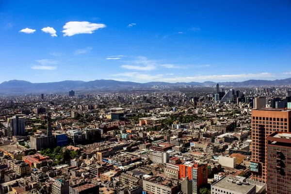 空に白い雲と晴れた日の背景に山と メキシコシティのダウンタウンの息をのむような街並み — ストック写真