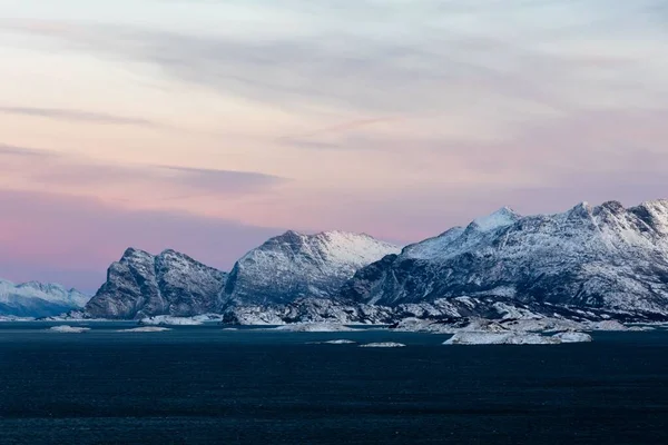 Vacker Utsikt Över Snöiga Berg Molnig Himmel Vid Solnedgången — Stockfoto