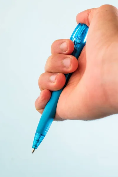 Uma Mão Segurando Uma Caneta Azul Contra Fundo Branco — Fotografia de Stock