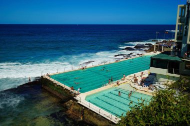 Bondi Sahili havuzunda binaların arka planında güzel bir insan fotoğrafı.