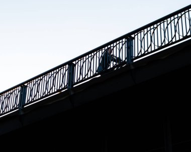 Köprüde bisiklet süren bir adamın düşük açılı görüntüsü. Moskova, Rusya.