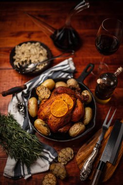 Ahşap bir masada tavada patates ve ızgara tavuğun dikey görüntüsü.