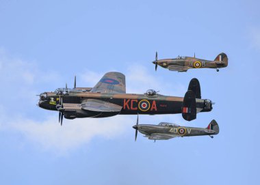 Lancaster, Spitfire ve mavi gökyüzünde uçan BBMF Kasırgası manzarası