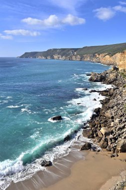 Portekiz 'de Atlantik Okyanusu kıyısındaki Cape Espichel' deki etkileyici uçurumlar mavi gökyüzünün altında