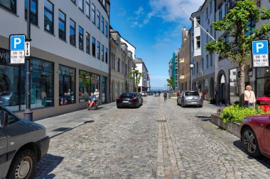 Norveç 'in tarihi Alesund kasabasında binaları, arabaları ve taş zemini olan bir cadde.