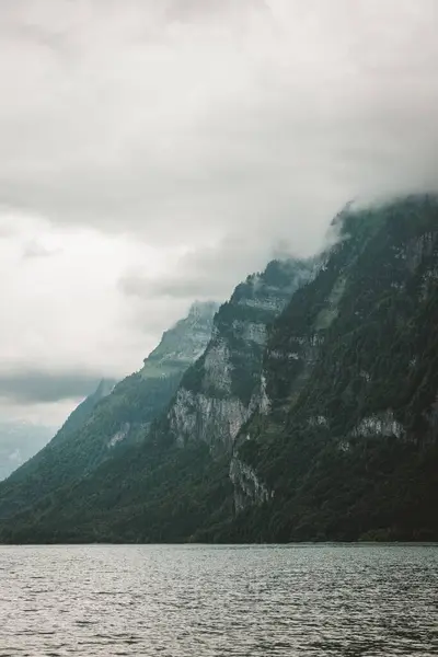 Vertikale Aufnahme Eines Sees Mit Berg Und Wolkenverhangenem Himmel — Stockfoto