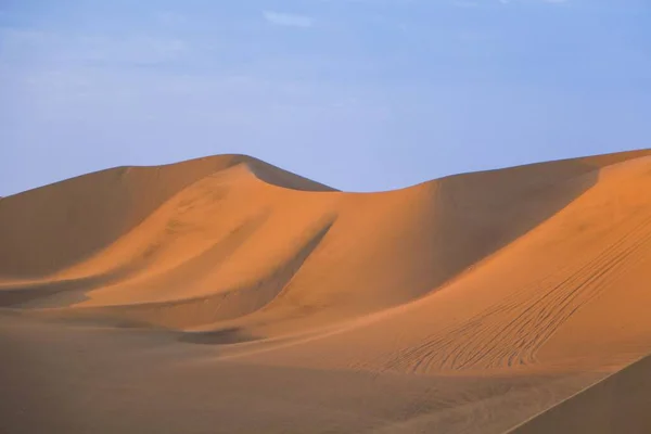 夕阳西下被太阳光照亮的沙漠中的巨大沙丘的垂直拍摄 — 图库照片