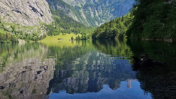 Μια Ήρεμη Λίμνη Που Περιβάλλεται Από Δέντρα Και Βουνά Αντανακλάται — Φωτογραφία Αρχείου