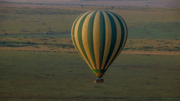 Een Heteluchtballon Met Gele Strepen Vliegt Een Groen Veld — Stockfoto