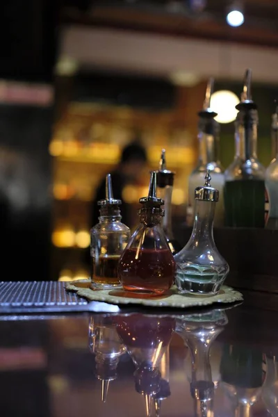 カクテルバーテーブルの上に酒と小さなボトルの垂直ショット — ストック写真