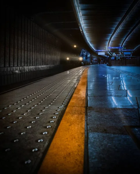 暗い色調で地下鉄駅に到着する列車の垂直ショット — ストック写真