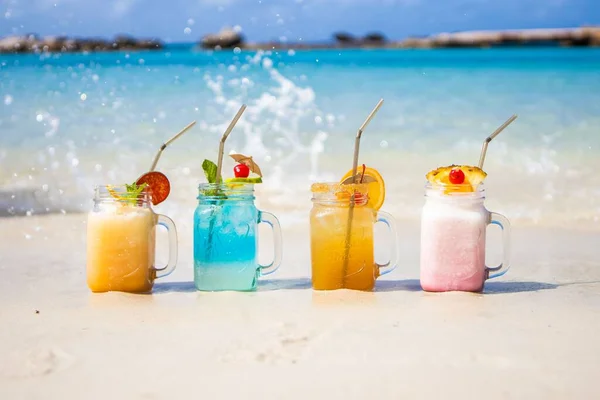 Bunte Erfrischende Cocktailgetränke Sandstrand Mit Plätscherndem Wasser — Stockfoto