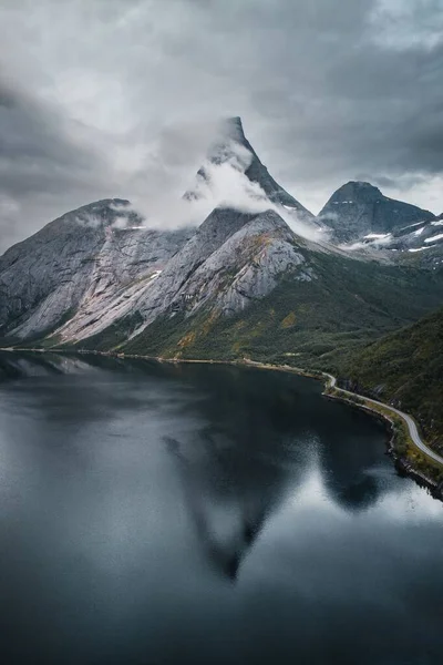 スイスの冬に雪に覆われた岩の丘に囲まれた湖の垂直ショット — ストック写真