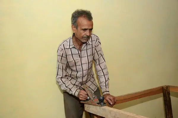 一个印度老人和一架飞机在一个木材厂工作 — 图库照片