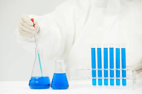 Médecin Travaillant Sur Des Éprouvettes Remplies Liquide Bleu Sur Table — Photo