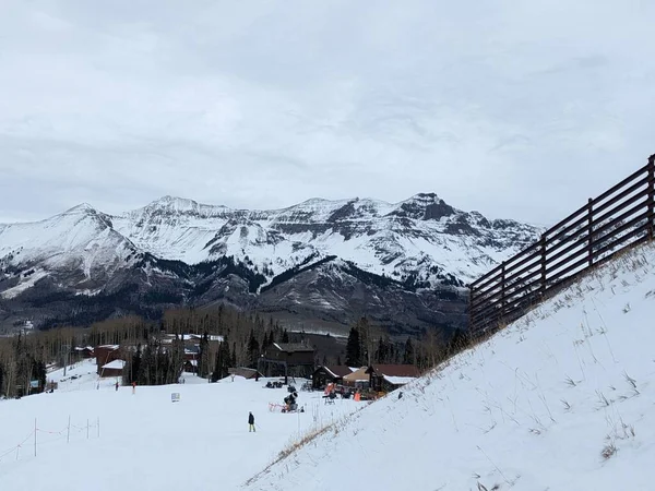 Arkasında Dağlar Olan Karla Kaplı Bir Yamaç Manzarası — Stok fotoğraf