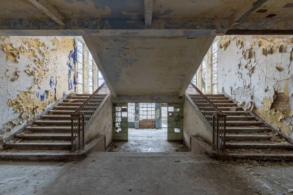 古老的废弃学校的内部 有对称的楼梯和风化的墙壁 — 图库照片