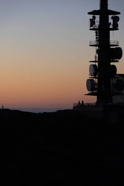 Eine Vertikale Aufnahme Der Silhouette Eines Telekommunikationsmastes Bei Sonnenuntergang — Stockfoto