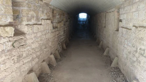 Een Tunnelpad Omringd Door Stenen Muren Die Naar Een Licht — Stockfoto