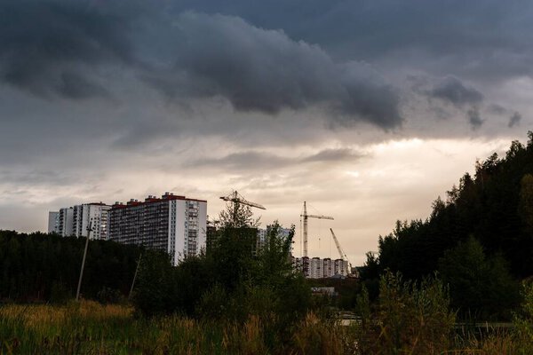 The building's construction with cranes on cloudy day. Moscow, Russia