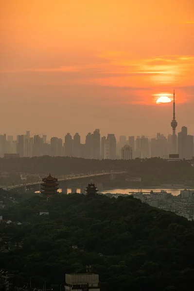 武漢市のスカイラインと背景の黄金の夕日と中国のパゴダの垂直ショット — ストック写真