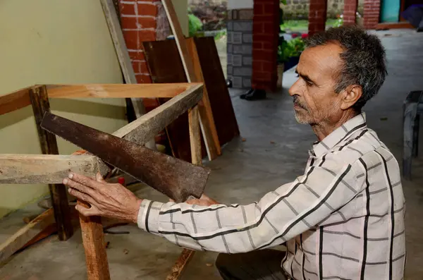 Egy Indián Öregember Aki Fűrésszel Dolgozik Egy Műhelyben — Stock Fotó