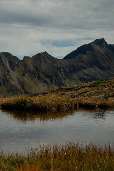 Tiro Vertical Lago Cercado Por Montanhas Rochosas Uma Área Rural — Fotografia de Stock