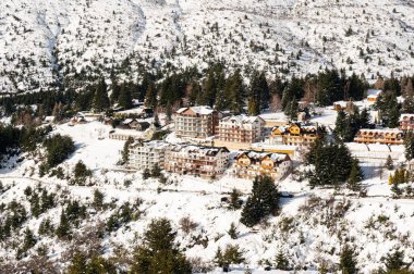 Bariloche 'deki karlı yamaçtaki güzel binalar.