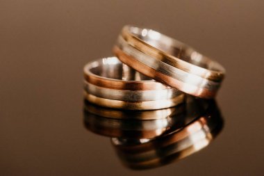 İki güzel alyans cam masa yüzeyine yansıyor.