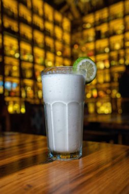 Bir gece kulübündeki ahşap bir masada limonlu pina colada kokteyli.