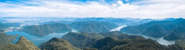 Taizhou 'daki göl arasındaki ağaç tepelerinin panoramik bir görüntüsü.