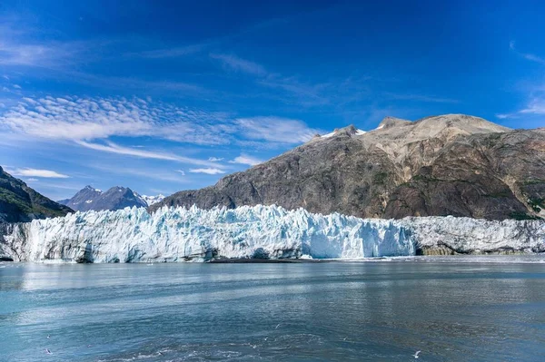 晴れた日に背景に大きな山がある凍った湖の大きな氷河 — ストック写真