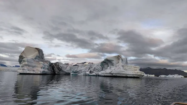 曇った空に向かって水の中に巨大な浮遊氷山 — ストック写真