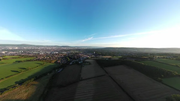 在蓝色天际线下的一片农田和一个城镇的空中拍摄 — 图库照片
