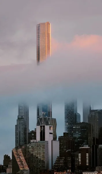 夕阳西下 云中高耸的摩天大楼的垂直镜头 — 图库照片