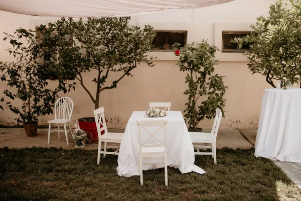 白いテーブルクロスと結婚式のために準備された花束キャンドルの装飾を持つ小さなテーブル — ストック写真