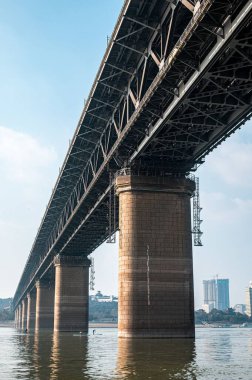 Wuhan Yangtze Nehri Köprüsü 'nün altından akan sular mavi gökyüzü ile Çin' in Wuhan şehrinde.