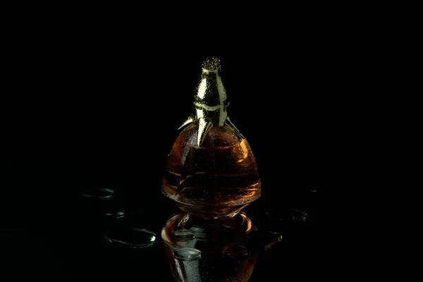 Una Botella Perfume Mujer Cubierta Agua Cae Sobre Fondo Negro —  Fotos de Stock