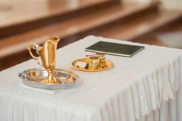 カトリック教会で洗礼のための黄金の容器に水と油の選択的焦点水平ショット — ストック写真