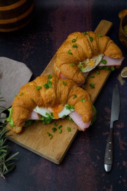 Pastırmalı ve yumurtalı kruvasan sandviçin düz manzarası.