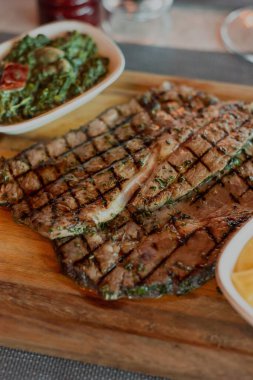 Birinci sınıf bir biftek lokantasının ortamında hazırlanmış leziz bir bifteğin dikey çekimi.