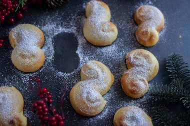 İsveç çöreklerinin üst görüntüsü, üstünde pudra şekeri ve kayıp bir kurabiye.