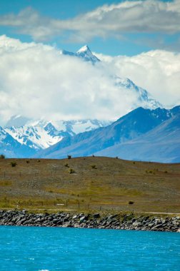 Yeni Zelanda 'da önplanda hidrolik kanalı olan Cook Dağı' nın üzerindeki bulutların dikey görüntüsü.